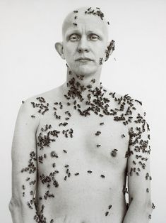 a man with lots of black bugs all over his body