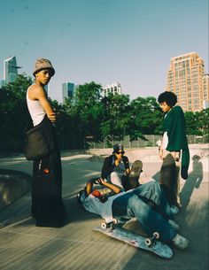 four skateboarders are sitting on the ground with their boards in front of them