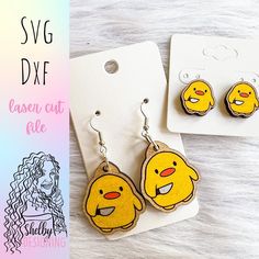 two pairs of earrings with yellow emoticions on them sitting next to each other