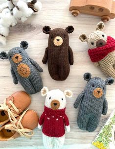 several knitted teddy bears sitting next to each other on top of a wooden table