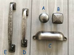 an assortment of door handles and knobs on a wooden surface with blue letters above them