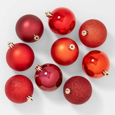 red christmas ornaments arranged in a circle on a white surface