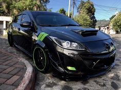 a black car with neon green stripes parked on the street