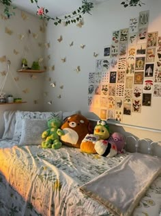 two stuffed animals sitting on top of a bed in a room with lots of pictures