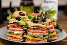 a sandwich cut in half sitting on top of a plate next to a bottle of wine