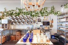 the interior of a coffee shop with plants growing on the wall and overhead lights hanging from the ceiling