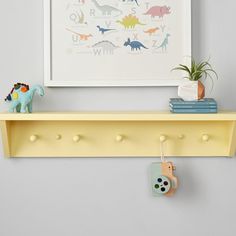 Add a pop of color and brilliant organization to your little one's wall with this vibrant shelf. Crafted of solid wood, it offers five pegs for hanging coats and backpacks, plus a shelf for grab-and-go items. KEY PRODUCT POINTS Handcrafted from solid poplar wood and finished with acrylic latex paint in a variety of vibrant colors (each sold separately). Pegs are made from 100% birch wood. BPA-, Phthalate- and Lead-free. Mounting hardware is included. Domestic. Shelf With Pegs, Kids Wall Shelves, Baby Shelves, Decorative Wall Shelves, Small Wall Shelf, Decorative Shelves, Wall Shelves Bedroom, Shelf Hooks, Kids Shelves