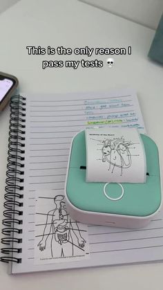 a notepad with a drawing on it next to a cell phone