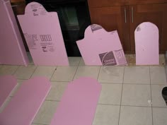 some pink boxes sitting on the floor in front of a stove top oven and cabinets