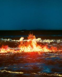 a fire hydrant spewing out flames into the ocean