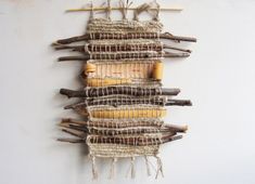 a wall hanging made out of sticks and yarn