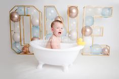 a baby sitting in a bathtub surrounded by balloons and letters that spell out 40