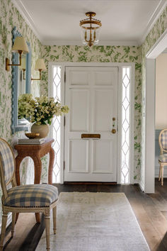 a white door sitting inside of a living room next to a table with flowers on it