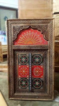 an intricately decorated wooden door with red and green designs on it's sides