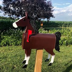 a horse mailbox sitting on top of a wooden post