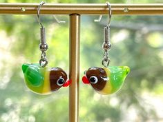 These black-cheeked yellow collared green lovebird glass beads earrings are cute and unique, which are perfect gifts for kids and friends.  They are made of the following: 🔹 Handmade glass beads: H9 x W10 x D18mm each bead is unique so there is a slightly different from bead to bead 🔹 Earring Hooks: gold plated or silver plated over brass 【PLEASE NOTE THE FOLLOWINGS BEFORE PURCHASE】 ✔ VAT, GST and any other taxes from your country are NOT included in the listing price. Buyers are responsible f Pet Sitter Gifts, Cute Parrot, Miniature Jewelry, Bird Mom, Green Parrot, Elephant Jewelry, Clip On Charms, Collared Greens, Elephant Necklace