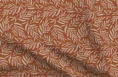 an orange and white fabric with leaves on it