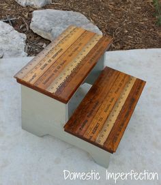 two wooden benches sitting next to each other on top of a cement slab in front of some rocks