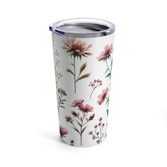 the tumbler is decorated with flowers and leaves