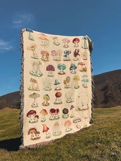 a blanket with mushrooms on it sitting in the grass