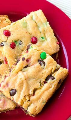 two cookies with m & m candies are on a red plate