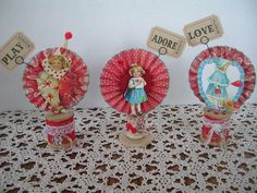 three paper fans are sitting on a doily