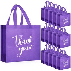 purple shopping bags with thank you written on the front and bottom, along with matching handles