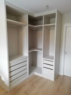 an empty white closet with drawers and shelves