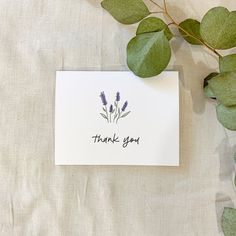 a thank you card with lavender flowers and greenery on a white sheet of paper