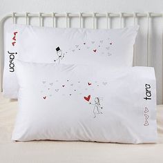 two pillows on top of a bed with the words i love you written on them