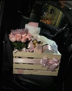 a wooden box filled with pink roses in the back seat of a car at night