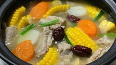 a close up of a bowl of food with carrots and corn on the cob