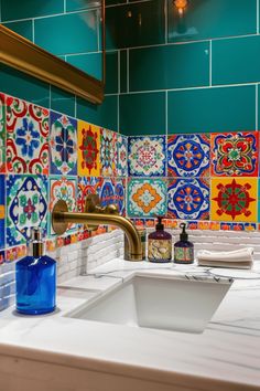 a bathroom sink with colorful tiles on the wall