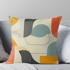 a throw pillow with an abstract design on the front and back of it, sitting on top of a couch