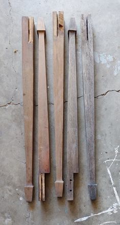 three pieces of wood sitting on top of a cement floor