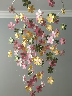 a mobile made out of paper flowers hanging from a ceiling