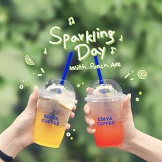 two people holding drinks with the words sparkling day written on them and green leaves in the background