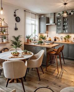 a kitchen filled with lots of furniture and wooden flooring next to a dining room table