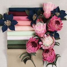 a bunch of flowers that are on top of a piece of paper with different colors