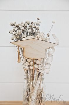 a vase filled with dried flowers on top of a wooden table