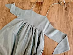 a dress laying on the floor next to a pair of scissors