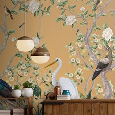 a wallpapered room with birds and flowers on the wall, two lamps hanging from the ceiling