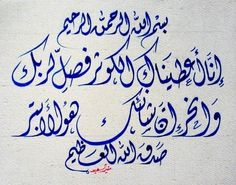 an arabic calligraphy written in blue ink on a white paper with writing underneath it