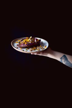 a plate with food on it being held by a person's arm in the dark