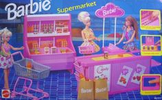 a barbie doll plays with her toy supermarket