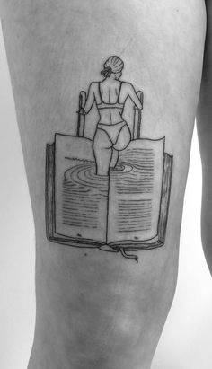 a person with a book tattoo on their leg