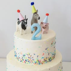 a birthday cake with three dogs on top and two candles in the shape of numbers