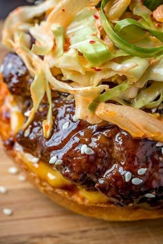 a hamburger with meat, coleslaw and slaw on it sitting on a wooden cutting board