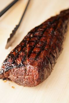 a piece of steak sitting on top of a wooden cutting board