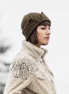 a woman wearing a hat and coat in the snow